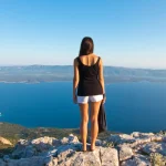 young woman looking panorama on brac highest peak, amazing view
