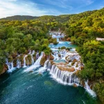 Krka, Croatia - Aerial view of the beautiful Krka Waterfalls in Krka National Park on a bright summer morning with green foliage, turquoise water and blue sky