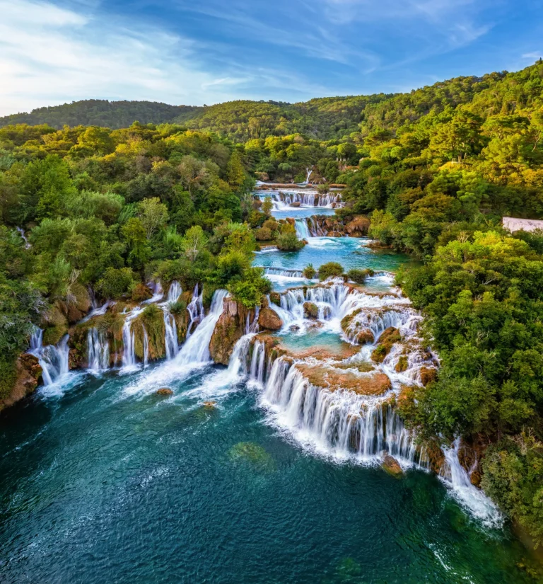 Krka, Croatia - Aerial view of the beautiful Krka Waterfalls in Krka National Park on a bright summer morning with green foliage, turquoise water and blue sky